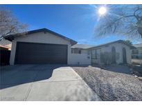 Ranch style home with two-car garage and gravel landscaping at 4905 Powell Ave, Las Vegas, NV 89121