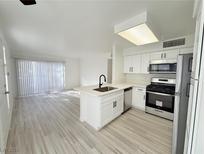 Modern white kitchen with stainless steel appliances and an island at 5222 Mandalay Springs Dr # 202, Las Vegas, NV 89120