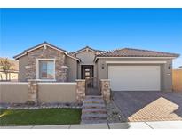 Single-story home with stone accents and a three-car garage at 10499 Skye Paseo Ave, Las Vegas, NV 89166