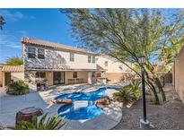 Gorgeous backyard pool and spa with desert landscaping, outdoor kitchen, and covered patio at 11276 Accademia Ct, Las Vegas, NV 89141