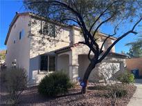 Two-story house with desert landscaping and a large tree in the front yard at 11276 Accademia Ct, Las Vegas, NV 89141