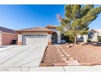 Single-story home with a landscaped front yard and attached two-car garage at 1235 Pagentry Dr, North Las Vegas, NV 89031