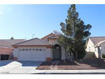 Single-story house with a two-car garage and landscaped front yard at 1235 Pagentry Dr, North Las Vegas, NV 89031