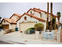 Two-story house with tile roof, attached garage, and gated front yard at 1972 Weenap Dr, Las Vegas, NV 89108