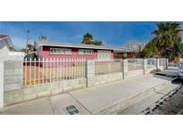 Ranch style home with a red brick exterior and a fenced front yard at 2105 Berkley Ave, Las Vegas, NV 89101