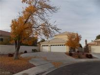 Two-story house with a three-car garage and mature trees in the front yard at 2662 Churchill Cir, Henderson, NV 89074