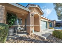 Inviting front porch with seating area, two-car garage, and landscaped yard at 5370 Cholla Cactus Ave, Las Vegas, NV 89141