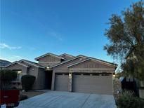 Two-story house with three-car garage and desert landscaping at 8318 Saddleback Ledge Ave, Las Vegas, NV 89147