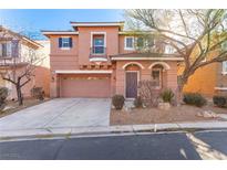 Two-story house with tan exterior, attached garage, and landscaping at 8809 Early Horizon Dr, Las Vegas, NV 89178