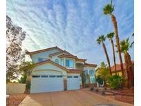 Two-story house with three-car garage and palm trees at 9703 Newport Coast Cir, Las Vegas, NV 89147