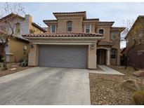 Two-story house with attached garage and Spanish-style architecture at 10046 Dancing Lasso Ct, Las Vegas, NV 89178