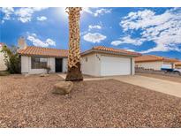 Single-story home with a white exterior, a two-car garage, and a desert landscape at 392 Dooley Dr, Henderson, NV 89015