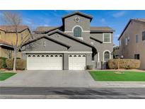 Two-story house with gray exterior, white garage doors, and landscaping at 5892 Rothbury Ave, Las Vegas, NV 89141