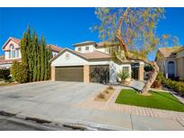 Two-story house with a three-car garage and landscaped front yard at 8466 Lambert Dr, Las Vegas, NV 89147