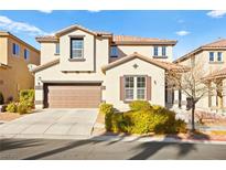 Two-story house with a tan exterior, brown garage door, and landscaping at 9124 Ironstone Ave, Las Vegas, NV 89143