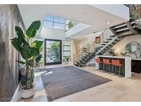 Bright entry with high ceilings, modern staircase, and stylish seating area at 103 San Martino Pl, Henderson, NV 89011