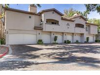 Tan two-story building with attached garages and landscaping at 113 Emerald Forest St # 203, Las Vegas, NV 89145