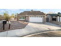 House exterior featuring a single-story house with a two-car garage and landscaped yard at 4878 Castle Rock Ct, Las Vegas, NV 89147