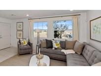 Spacious living room with gray sectional sofa and large windows at 925 Watford Pl, Henderson, NV 89011