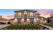 Two-story house with a stone facade, balconies, and a landscaped lawn at 9605 Verlaine Ct, Las Vegas, NV 89145