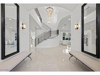 Grand foyer features tile flooring, soaring ceilings, custom lighting and a curved staircase at 9605 Verlaine Ct, Las Vegas, NV 89145