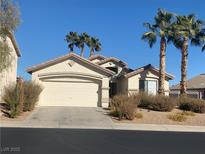 One-story house with attached garage, desert landscaping, and palm trees at 44 Blaven Dr, Henderson, NV 89002