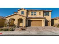 Two-story house with tan exterior, brown garage door, and landscaped yard at 3138 Abetone Ave, Henderson, NV 89044