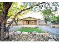 Ranch style home with landscaped yard, brick accents and large trees at 749 Rossmore Dr, Las Vegas, NV 89110