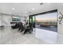 Modern dining area with glass table, black chairs, and fireplace at 1168 Spago Ln, Henderson, NV 89052