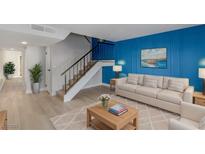 Light and airy living room with blue accent wall and stairs to upper level at 4165 Mississippi Ave, Las Vegas, NV 89103