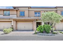 Tan two-story townhome with attached garage and landscaping at 10375 Pescado Ln, Las Vegas, NV 89135
