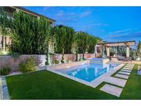 Stunning pool and spa with an outdoor kitchen nestled in a private landscaped backyard at 177 Cactus Sunrise St, Las Vegas, NV 89138