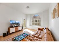 Bright living room with a leather sectional sofa and large TV at 3125 N Buffalo Dr # 2136, Las Vegas, NV 89128