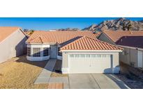 Single-story house with tile roof, two-car garage, and desert landscaping at 2594 Florida Keys Dr, Las Vegas, NV 89156
