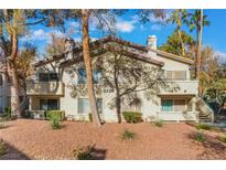 Exterior of a light beige condominium building with landscaping and trees at 3225 Casey Dr # 103, Las Vegas, NV 89120