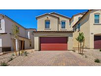 Charming two-story home features a red garage door and a brick driveway, surrounded by desert landscaping at 334 Taylor St, Henderson, NV 89015