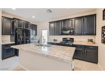 Modern kitchen with granite countertops and dark cabinetry at 4104 Midnight Crest Ave, North Las Vegas, NV 89031