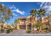 Two-story house with a large driveway and palm trees in front at 7642 Riva Ridge St, Las Vegas, NV 89149