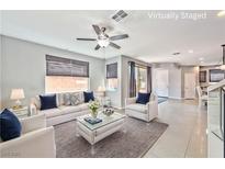 Bright living room features neutral decor, modern ceiling fan and lots of natural light at 2694 Marvel Astoria St, Henderson, NV 89044