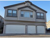 Three car garage exterior of home with stucco facade and updated lighting at 6431 Saddle Up Ave # 103, Henderson, NV 89011