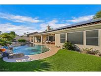 Inviting backyard oasis with a sparkling pool, waterfall, and lush landscaping at 7511 Bridlehorne Ave, Las Vegas, NV 89131