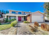 Two-story house with red door, brick accents, and landscaped yard at 1510 Marita Dr, Boulder City, NV 89005