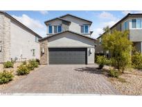 Two-story house with gray exterior, dark garage door, and landscaped front yard at 2720 High Echelon Rd, North Las Vegas, NV 89086