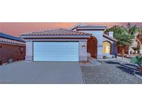 Single-story house with a two-car garage and landscaped yard at 6458 Bluehurst Ave, Las Vegas, NV 89156