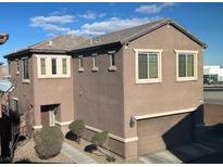 Tan two-story house with attached garage and landscaping at 658 Forest Peak St, Henderson, NV 89011