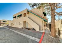 Tan stucco condo building with green accents and a staircase at 6750 Del Rey Ave # 262, Las Vegas, NV 89146