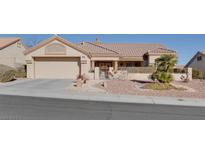 Single-story home with a two-car garage and nicely landscaped front yard at 9520 Yucca Blossom Dr, Las Vegas, NV 89134