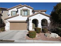 Two-story house with a tan garage door and landscaping at 10418 Prairie Mountain Ave, Las Vegas, NV 89166