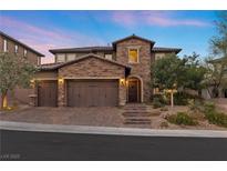 Two-story home with brick exterior, three-car garage, and landscaped yard at 11952 Girasole Ave, Las Vegas, NV 89138