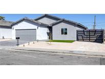 Charming single-story home with modern gray and white exterior, desert landscaping, and secure gated entry at 1308 E Nelson Ave, North Las Vegas, NV 89030